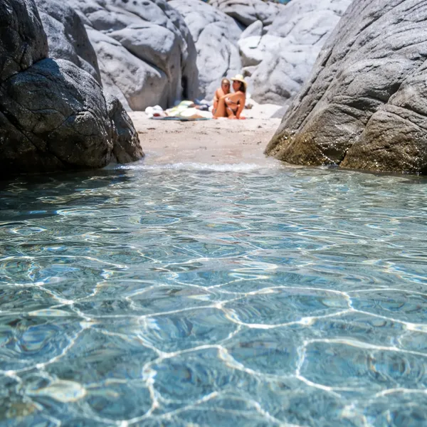 Eau cristalline de Pietragrande au pied des rochers de granit, petite plage nichée dans la crique