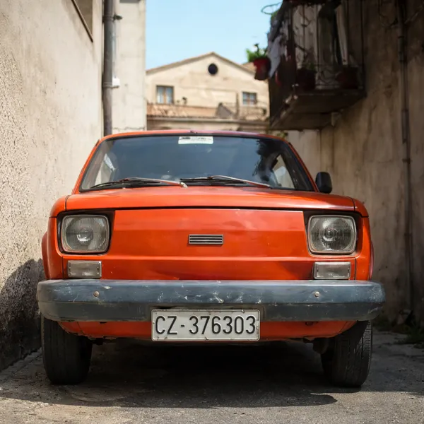 Fiat 500 ancienne orange garée dans une ruelle étroite de Santa Caterina Superiore, village de Calabre