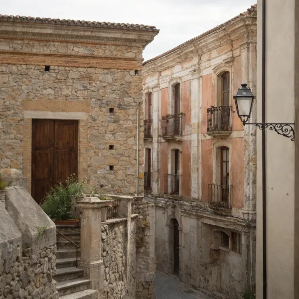 Escalier et ruelle en pierre dans le centre ancien de Santa Caterina Superiore, avec façades patinées et lampadaire