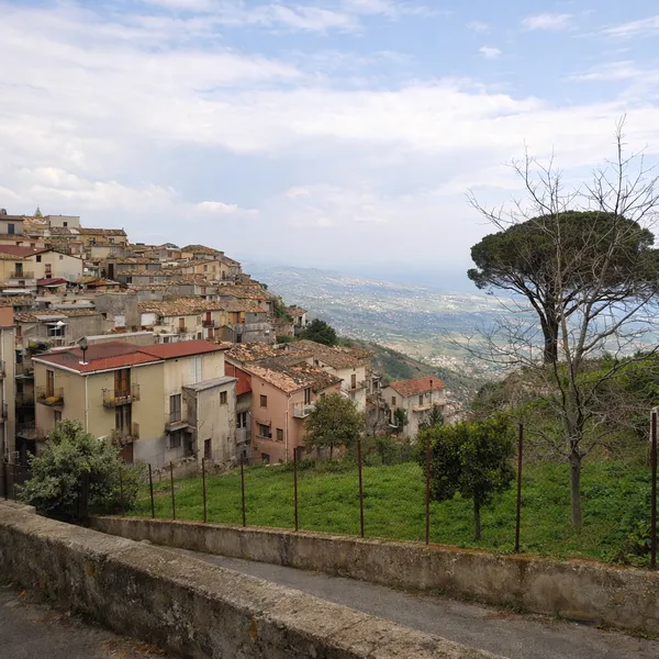 Vue latérale de Santa Caterina Superiore en Calabre, maisons en terrasses sur la colline avec la mer Ionienne à l’horizon